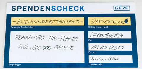 Brigitte Vöster-Alber wręcza czek na datki od GEZE GmbH Frithjofowi Finkbeinerowi (Plant-for-the-Planet) oraz ambasadorom sprawiedliwości klimatycznej Kirze Groß i Evie Keller.
