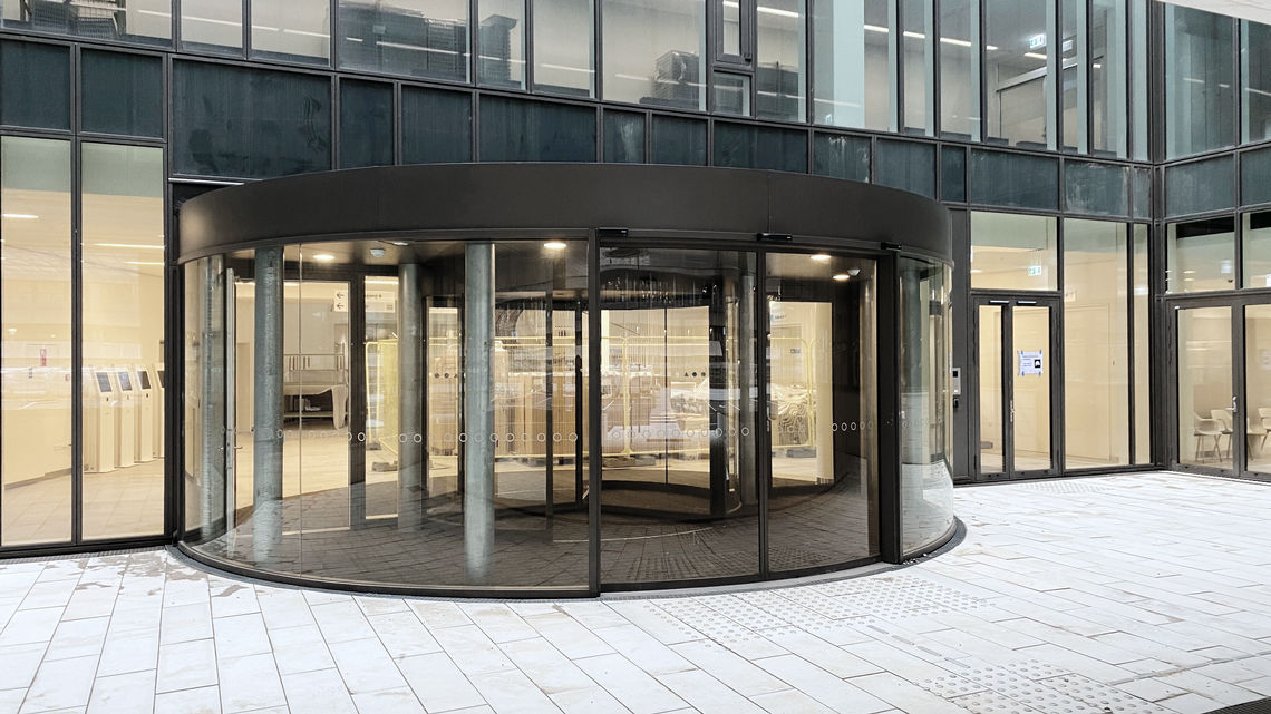 Smart glass façade with revolving door and Slimdrive SC at the patient entrance.