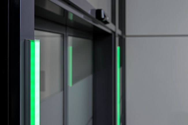 Le signal visuel vert sur la porte automatique indique que les personnes peuvent entrer dans le bâtiment.