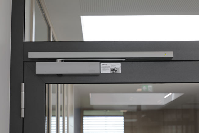 GEZE TS 5000 R overhead door closer with integrated smoke switch control unit, which sends a signal to automatically close the door in case of 