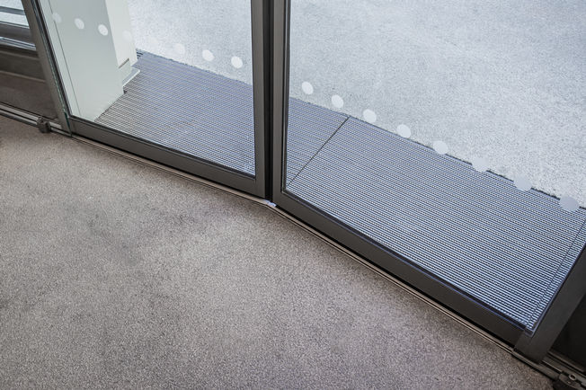 Slimdrive SLV Dokazana vrata s kliznim pogonom tvrtke GEZE osiguravaju standardnu zaštitu i noćno zaključavanje, unatoč konstrukciji fasade pod kutom.