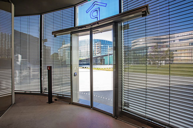 Slimdrive SLV Dokazana vrata s kliznim pogonom tvrtke GEZE osiguravaju standardnu zaštitu i noćno zaključavanje, unatoč konstrukciji fasade pod kutom.