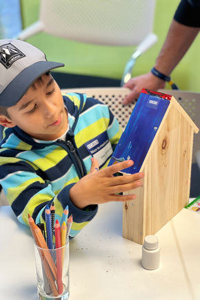 Child at the GEZE honey harvesting event paints an insect hotel