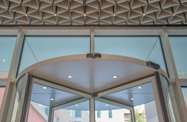 GEZE ITA - HQ Deloitte - close up canopy Revo.PRIME Low-angle view of the revolving door canopy, emphasizing the integrated sensors and expressing innovation, sophistication and cutting-edge design