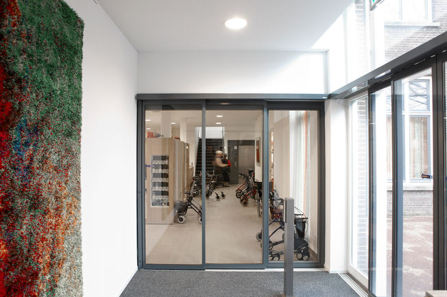 Automatic sliding door drive Slimdrive SLT, installed at the care homes of St. Elisabeth, Rosendaal Automatic telescopic sliding door system for use in narrowest glass façades with two parallel surface mounted tracks, the door leaves lead and achieve high opening widths.