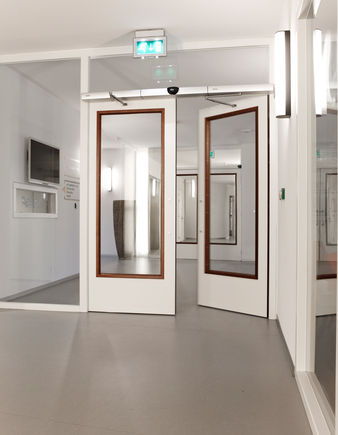 Swing door system - Slimdrive EMD-F IS, St. Elisabeth Electromechanical swing door system for double leaf fire and smoke protection doors with integrated mechanical closing sequence control