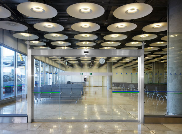 Puertas correderas de vidrio en el hall de entrada del Aeropuerto de Madrid, vista frontal