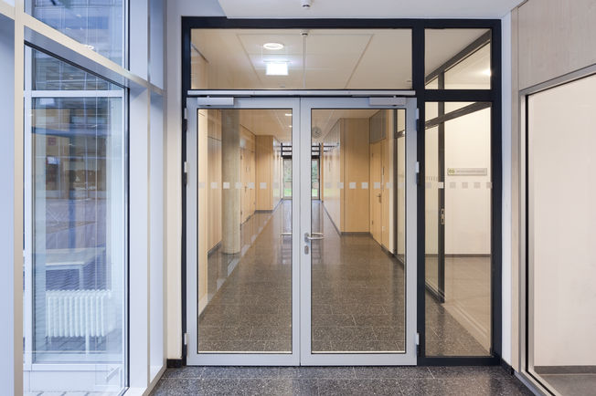 Överliggande dörrstängare med glidskena TS 5000 R-ISM Brandcellsdörr med TS 5000 R-ISM, överliggande dörrstängare med glidskena för dubbeldörrar med integrerad koordinator och rökdetektor, installerad på yrkesskolan i Friedrichshafen.