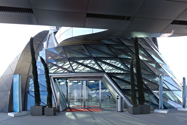 Pogon zaokretnih vrata - TSA 160 NT u BMW Welt Elektrohidraulični pogon zaokretnih vrata omogućuje posjetitelju da s lakoćom pomiče teška vrata (od težina do 250 kg). Ova lakoća stvara osjećaj prolaska bez prepreka. Osim toga, TSA 160 NT se savršeno uklapa u ukupnu sliku BMW svijeta.