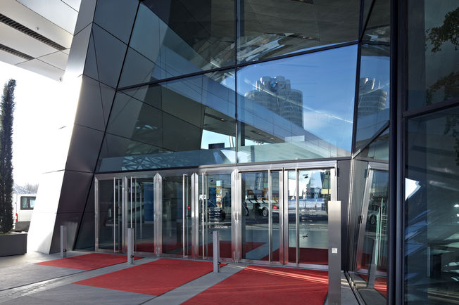 Zatvarač vrata - TS 5000 L + pogon zaokretnih vrata - TSA 160 NT u BMW Welt Kombinacija zatvarač vrata s kliznom vodilicom i elektrohidraulički pogon zaokretnih vrata dovode do toga da posjetitelji BMW svijeta iskuse osjećaj prolaska bez prepreka.