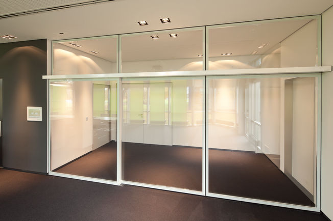 Automatic sliding door drive Slimdrive SL NT with integrated all-glass system (IGG) in the company building of GEZE GmbH, Leonberg Automatic linear sliding door system with IGG, low height and clear design line