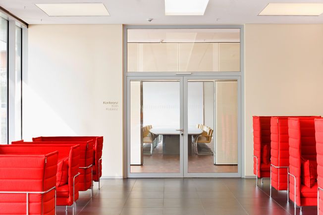 Bovenliggende deurdranger met glijrail TS 5000 ISM, geïnstalleerd in het Rheinlandhaus in Keulen Deurdranger voor tweevleugellige deuren met sluitvolgorderegeling en geïntegreerde openingsdemping, waardoor krachtig uitzwaaiende deuren worden afgeremd.