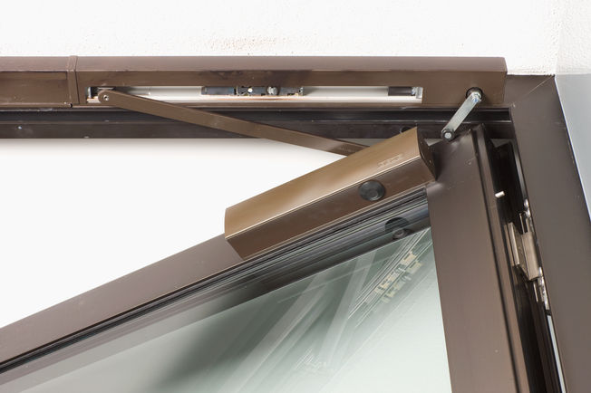 Ajtócsukó TS 5000 L-R-ISM, a kölni Generali Deutschland AG-nél. TS 5000 L-R-ISM felső szerelésű ajtócsukó kétszárnyú ajtókhoz integrált, láthatatlan csukássorrend szabályozással felszerelve, az ajtószárnyra a pánttal ellentétes oldalra felszerelve. Tűz esetén működésbe lép az integrált füstjelző, és az ajtó automatikusan becsukódik.