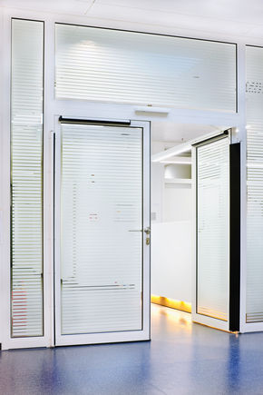 Ajtómozgató - Slimdrive EMD F-IS, Düsseldorf klinika Elektromechanikus ajtómozgató rendszer kétszárnyú tűz- és füstgátló ajtókhoz, integrált mechanikus csukássorrend szabályozással