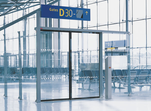 Skjutdörrsautomatik Slimdrive SLT på flygplatsen Köln-Bonn Automatiskt skjutdörrssystem med teleskop för användning i mycket smala glasfasader med två parallella löpskenor som leder dörrbladen och uppnår mycket stora öppningsbredder.