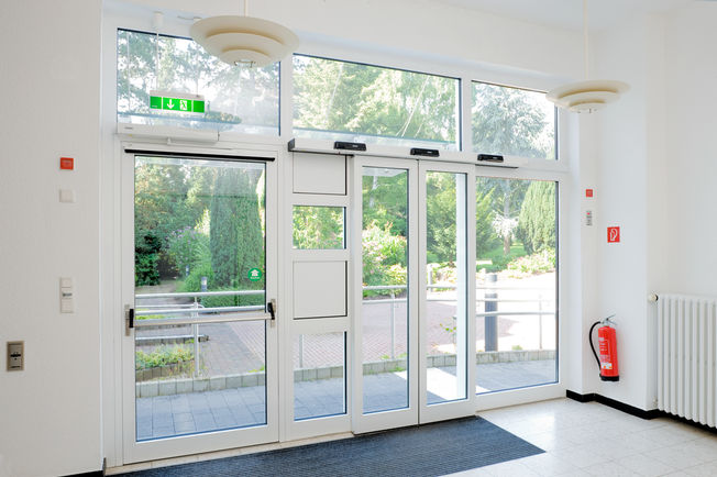 Swing door drive - Slimdrive SL/ EMD + guide rail + bar, Financial Academy Bonn Emergency exit protection systems save lives and protect buildings. Safety demands are high. System solutions from GEZE ensure optimum locking, control and opening of emergency exits.