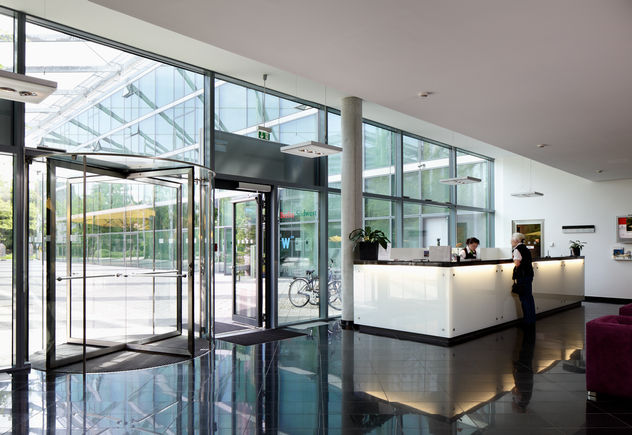 Revolving door system - TSA 325 GG + swing door drive - TSA 160 NT, FU Campus Dahlem Three- and four-leaf all-glass door systems can be operated manually, Interior and exterior doors with high access frequency