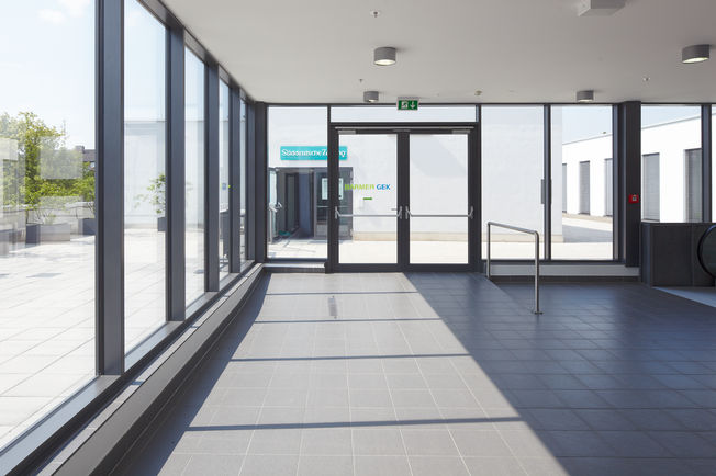 Overhead door closer with guide rail TS 5000 L-ISM, installed at City Point in Fürstenfeldbruck. Overhead door closer system with guide rail, for opposite hinge side, for double leaf doors with anti-panic function and closing sequence control.