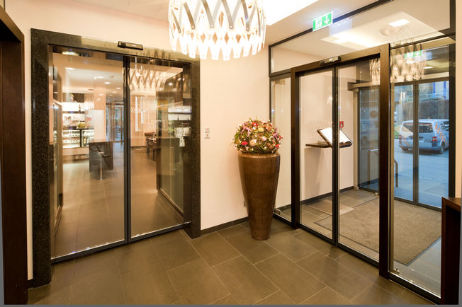 Automatic sliding door Slimdrive SL-FR with IGG, side panels and fanlight as a vestibule system at the Eberhards Hotel and Restaurant in Bietigheim-Bissingen Specially designed for installation in emergency exits, the sliding door system finds GEZE Slimdrive SL-FR application when safety is a priority.