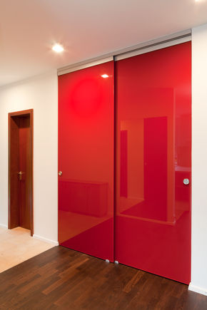 Perlan 140 on a red glass door. Sliding fitting for glass doors with draw-in damper on one or both sides