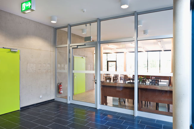 Bovenliggende deurdranger met glijrail TS 5000 R met rookschakelaarcentrale Bovenliggende deurdranger met glijrail TS 5000 R met rookschakelaarcentrale, geïnstalleerd in de Kunsthochschule Alfter in Alfter bij Bonn. geschikt voor eenvleugelige deuren tot 1400 mm vleugelbreedte.