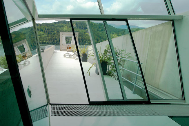 Automatischer Schiebetürantrieb Slimdrive SL geneigt in der Villa Soravia, Millstatt Österreich Automatisches Linear-Schiebetürsystem für den Einsatz an geneigten Glasfassaden