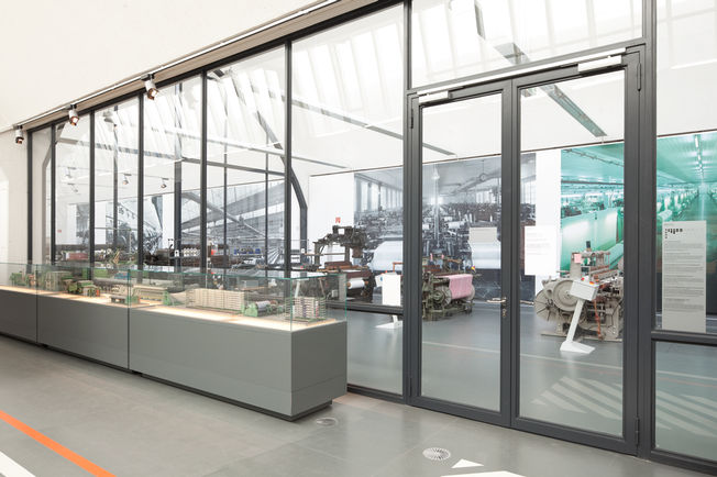 Overhead door closer with guide rail system TS 5000 ISM, installed in the Textile and Industrial Museum in Augsburg. Door closer for double leaf doors with closing sequence control and with integrated back check, which causes the strongly opened doors to be slowed down.