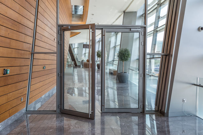 Double-leaf glass swing door, one door leaf open.