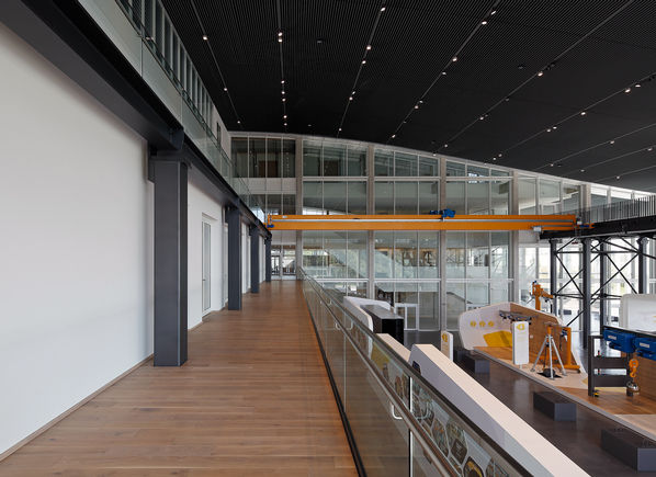 Entrée de la poutrelle de la grue avec une balustrade en verre sur la droite.