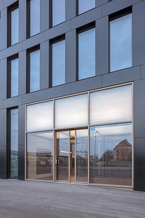 Sliding door drive Powerdrive PL at the entrance to the Grosspetertower in Zurich Automatic linear sliding door system for large and heavy doors with independent fault detection and logging