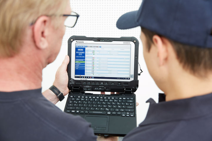 Zwei GEZE Servicetechniker schauen in einen Laptop