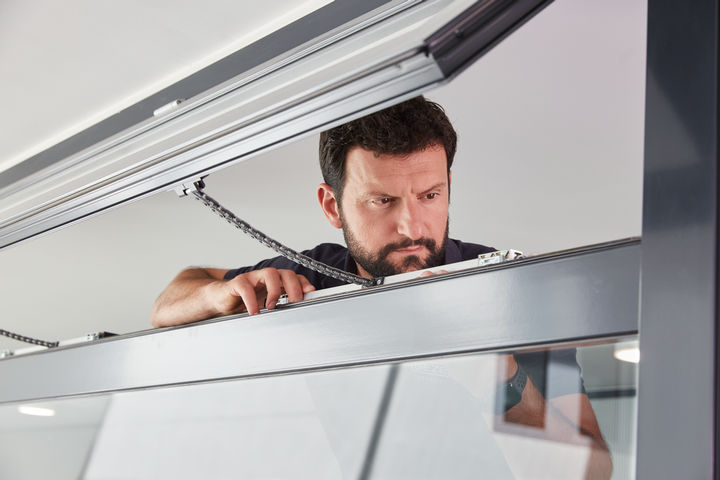 A GEZE service technician carrying out maintenance on a window