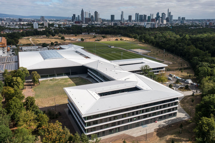 Luftaufnahme des neuen DFB-Campus mit Frankfurter Skyline im Hintergrund.