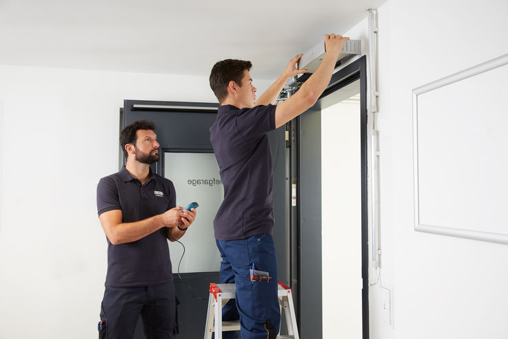 Zwei GEZE Servicemitarbeiter beim Einbau eines Türschließers