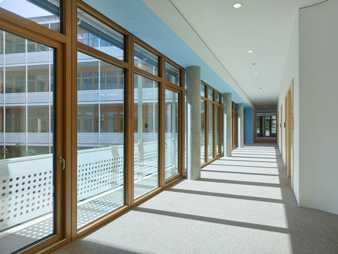 Vedere de interior asupra unui culoar din clădirea dm-dialogicum, cu sisteme de uși și ferestre marca GEZE.