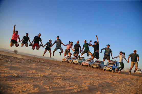 Entrants in the 4L Trophy leap into the air with joy on their arrival in Morocco.