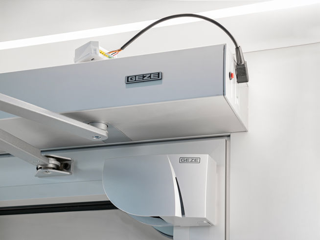 Nahansicht eines Powerturn-Drehtürantriebs an einer Tür mit dem myGEZE Bluetooth Modul.