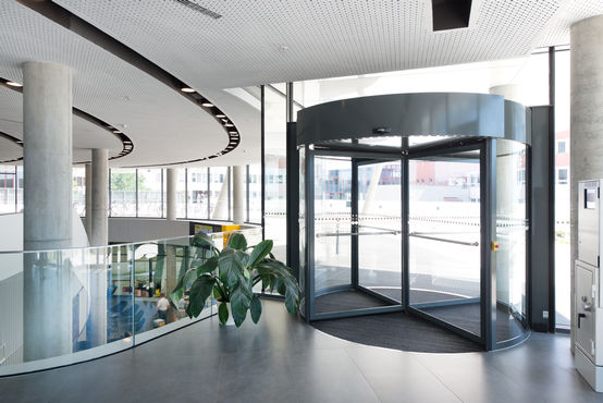 I sistemi di porta girevole automatici della gamma TSA 325 NT nel Centro per la mobilità "Club automobilistico, motociclistico e di touring austriaco" (ÖAMTC) di Vienna. Immagine: Sigrid Rauchdobler per GEZE GmbH