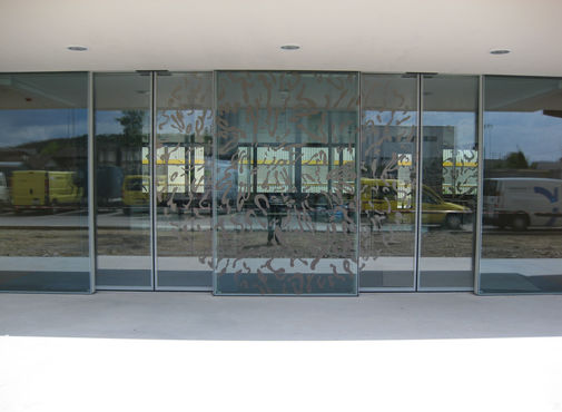 Glazen schuifdeuren met zonnedesigns in de hoofdingang. 