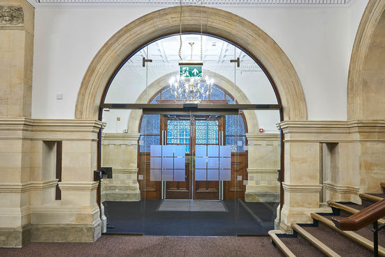 Automatische Schiebetüren aus Glas teilen den Eingangsbereich des Rathauses neu auf. 