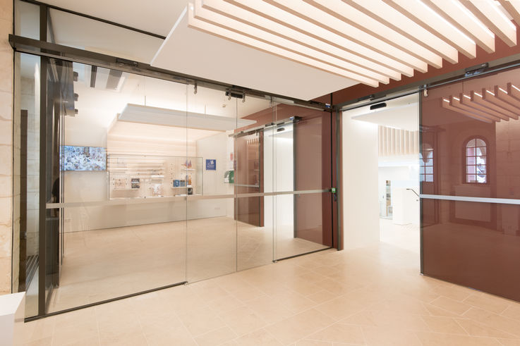 Ganzglasschiebetüren und Zutrittskontrollsysteme trennen öffentliche Bereiche von den Büroräumen. 