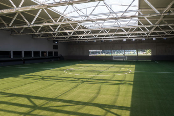 Hala piłkarska DFB z grą cieni na boisku i widokiem na konstrukcję dachu.