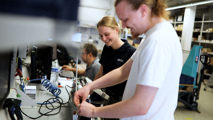 Potrait zweier Mitarbeitenden beim Arbeiten