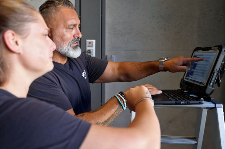 Zwei GEZE Servicetechniker schauen in einen Laptop und besprechen sich