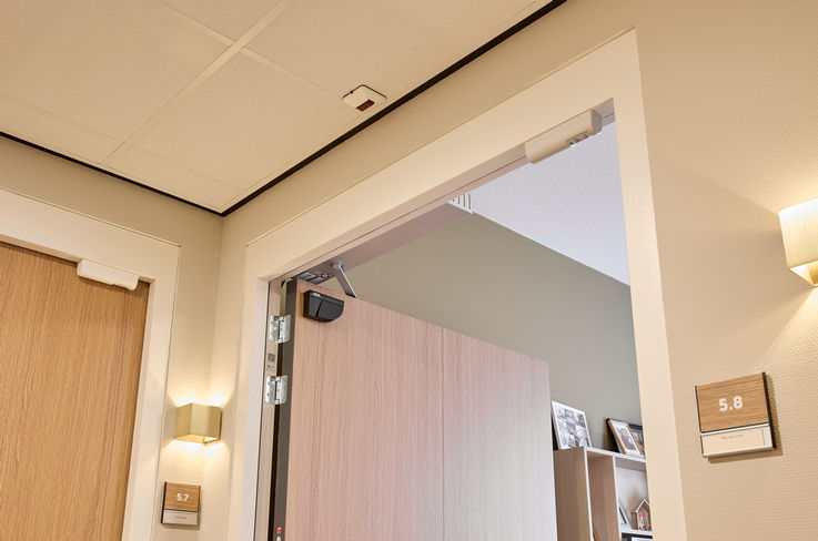 View into a door frame at an open door with a sensor for automatic doors.