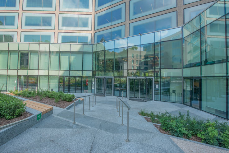 View of the entrance area of a large office building with a glass façade