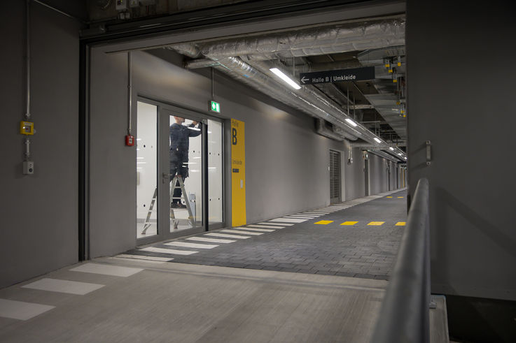 Servicetechniker von GEZE Service beim Einbau eines Türschließers an einer großen Glastüre