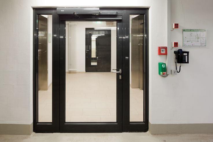 Electro-hydraulic swing door drive system for 2-leaf fire and smoke protection doors with integrated closing sequence control in the Augustinum retirement complex, Stuttgart.