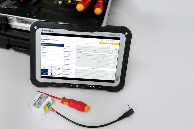 Service Toughpad with open software interface, next to it a Bluetooth module, screwdriver and toolbox in the background.