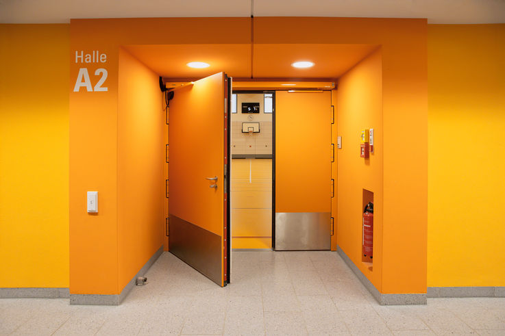 Orange Tür zur Halle A2 im Sportpark am Bildungscampus Freiham